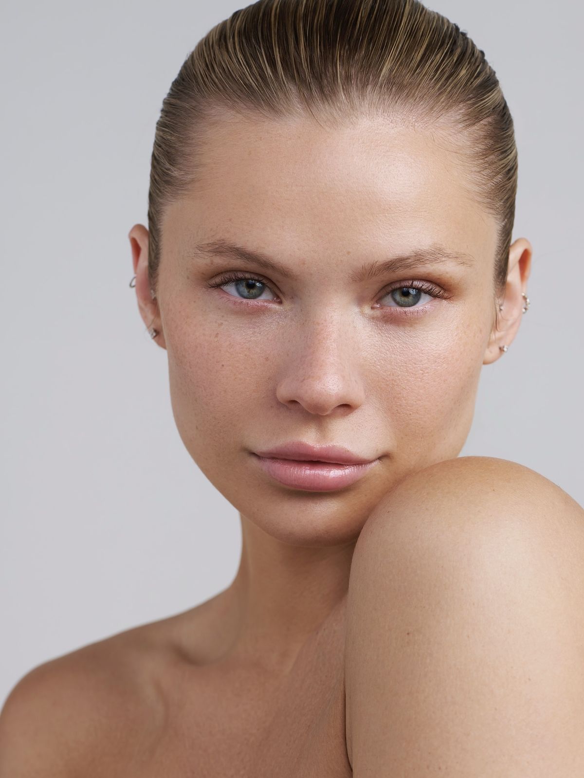Close-up of a woman with a neutral expression on a gray background
