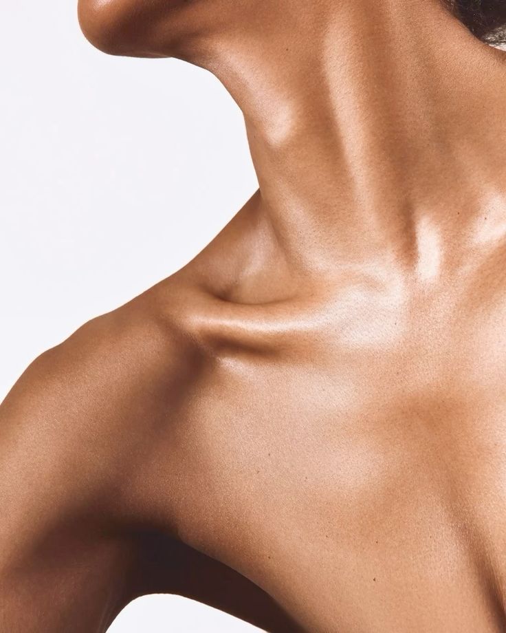 Close-up of a person's shoulder and neck with a neutral background