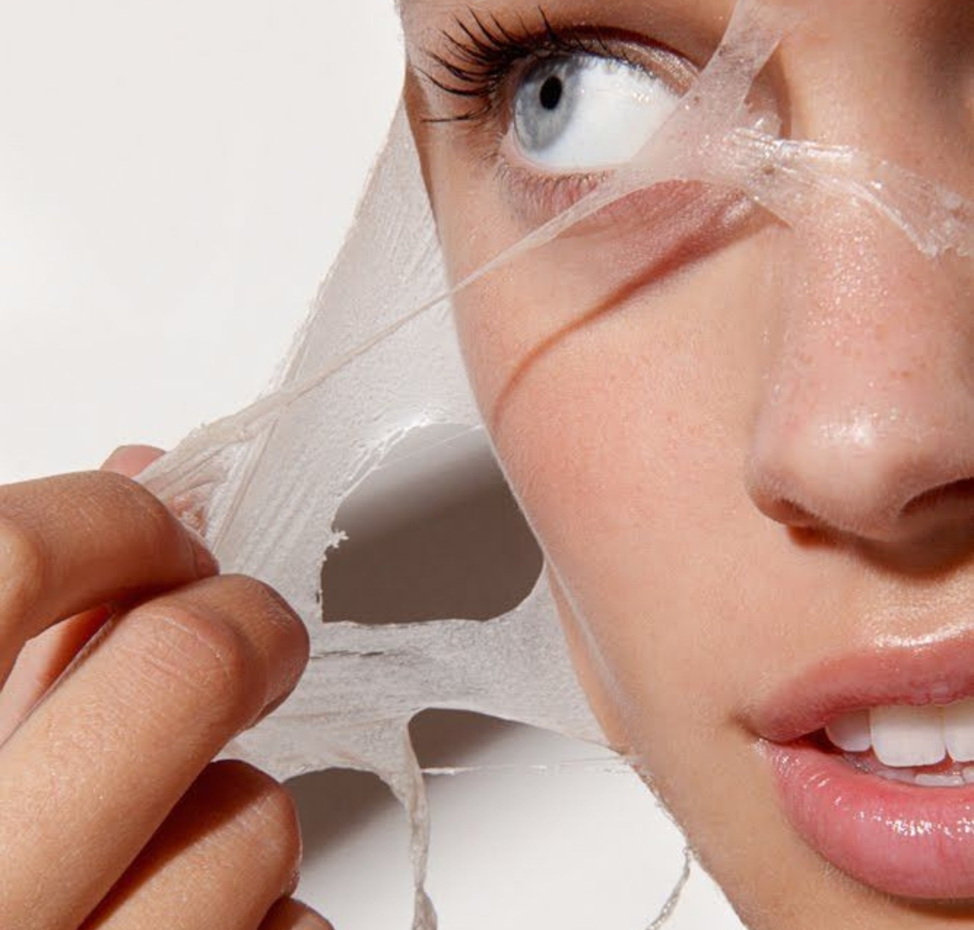 Person applying a face mask with a white background